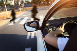Car stopped at crosswalk as pedestrians cross, avoiding pedestrian accident