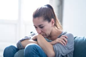 A close-up shot of a woman's clasped hands as she talks about workers compensation and mental health