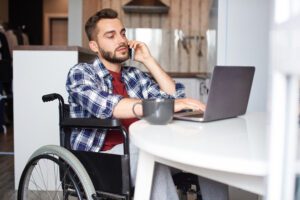 man in wheelchair on computer researching information on suing doctors