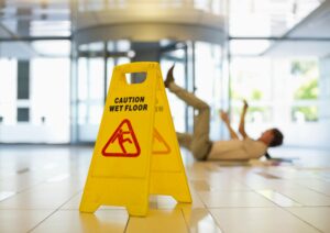 Caution sign with man in the background on the floor from slip and fall accident in Waldorf, MD