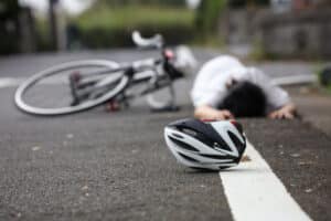 Man on the ground after being hit on bicycle by a hit-and-run driver