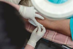 Doctor applying clean dressing to a dog bite wound on a patient's forearm.